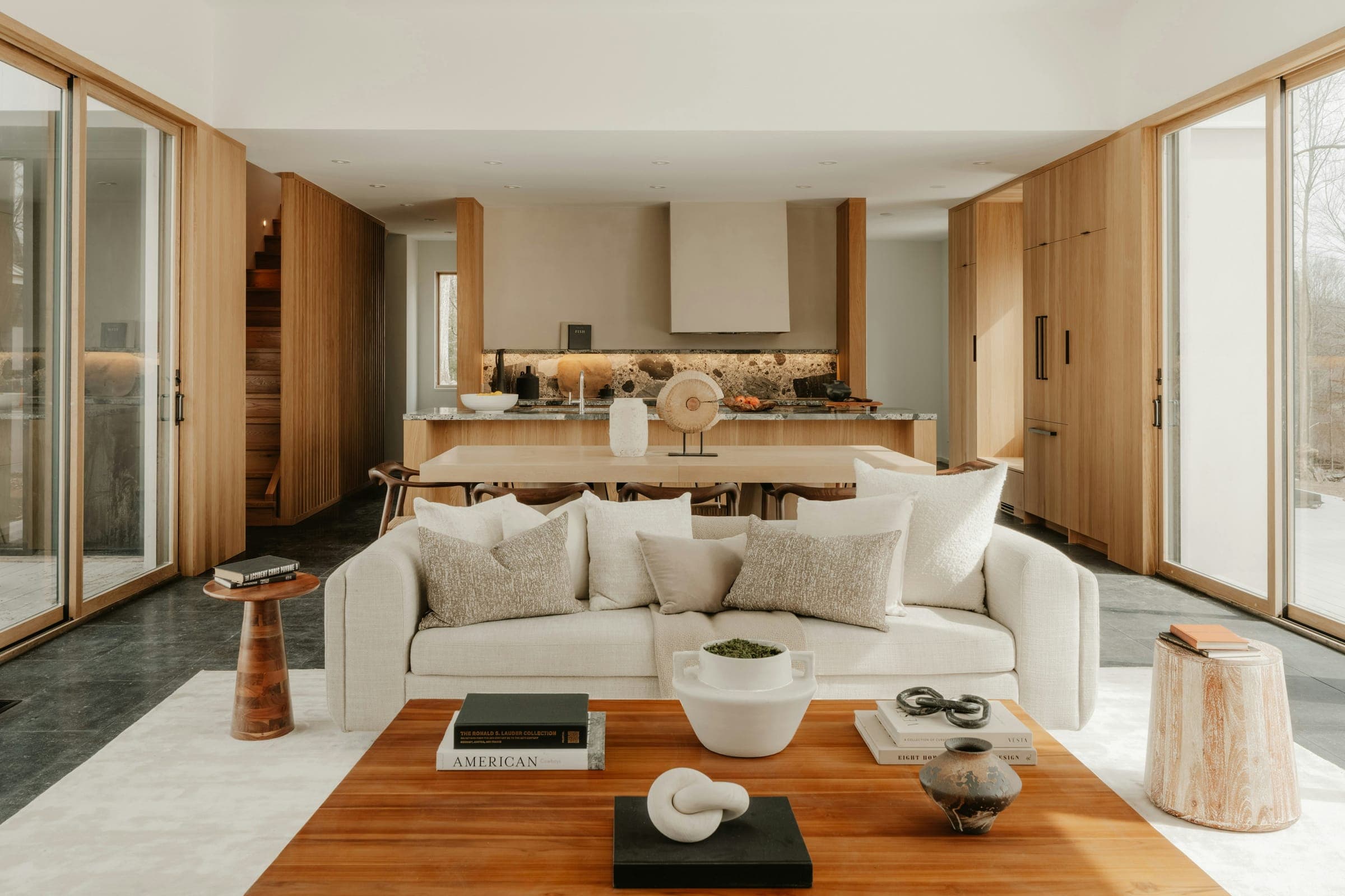 Open-plan living room with a cream sofa, wooden coffee table and an oak kitchen behind.