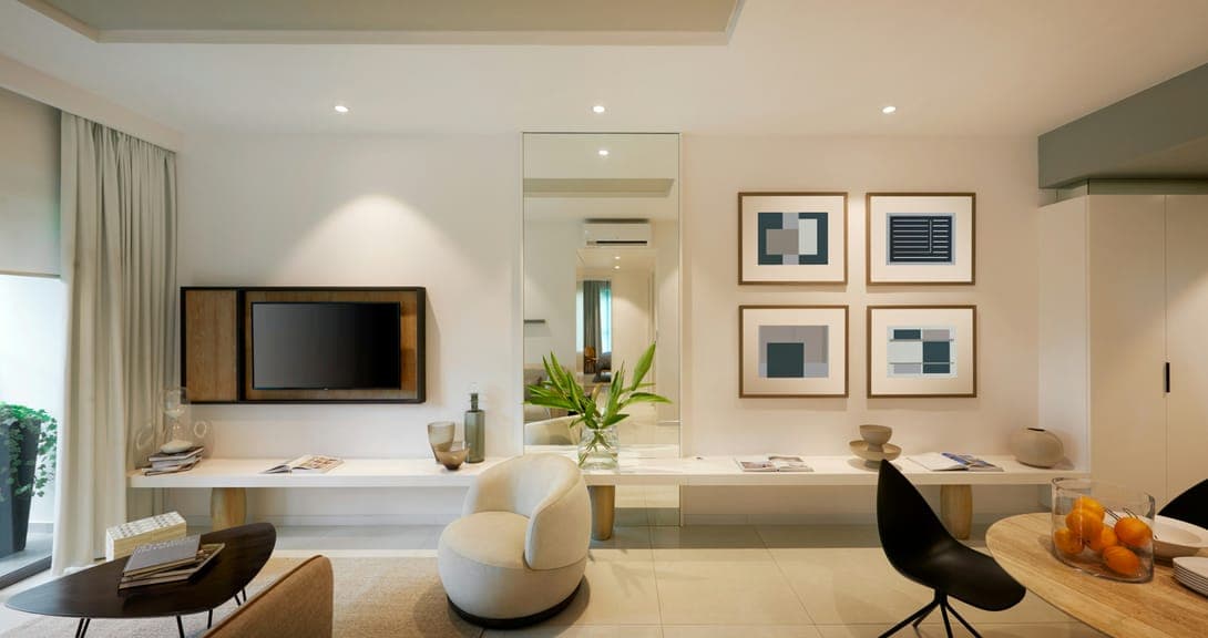 Bright living area with white armchair, long floating shelf, mirror and framed geometric prints.