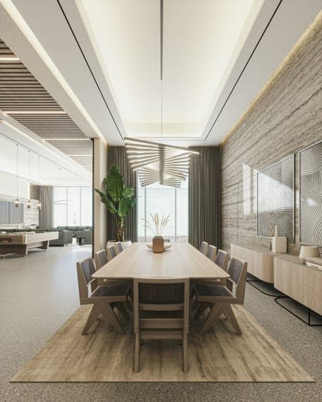 Dining room with long wooden table, sculptural pendant, travertine wall and a lounge beyond.