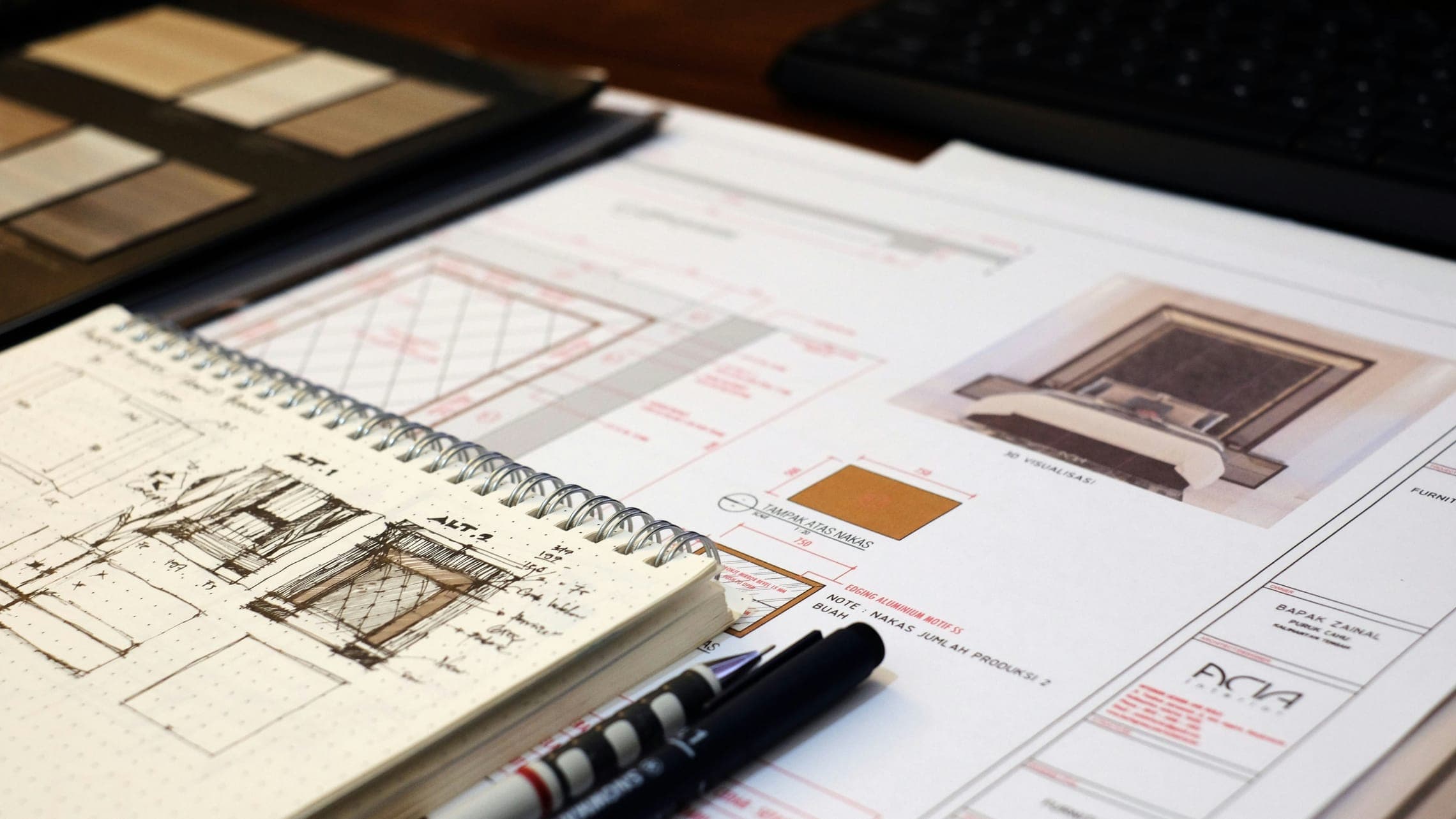 Interior design drawings, a sketchbook of furniture sketches, fineliner pens and material samples.
